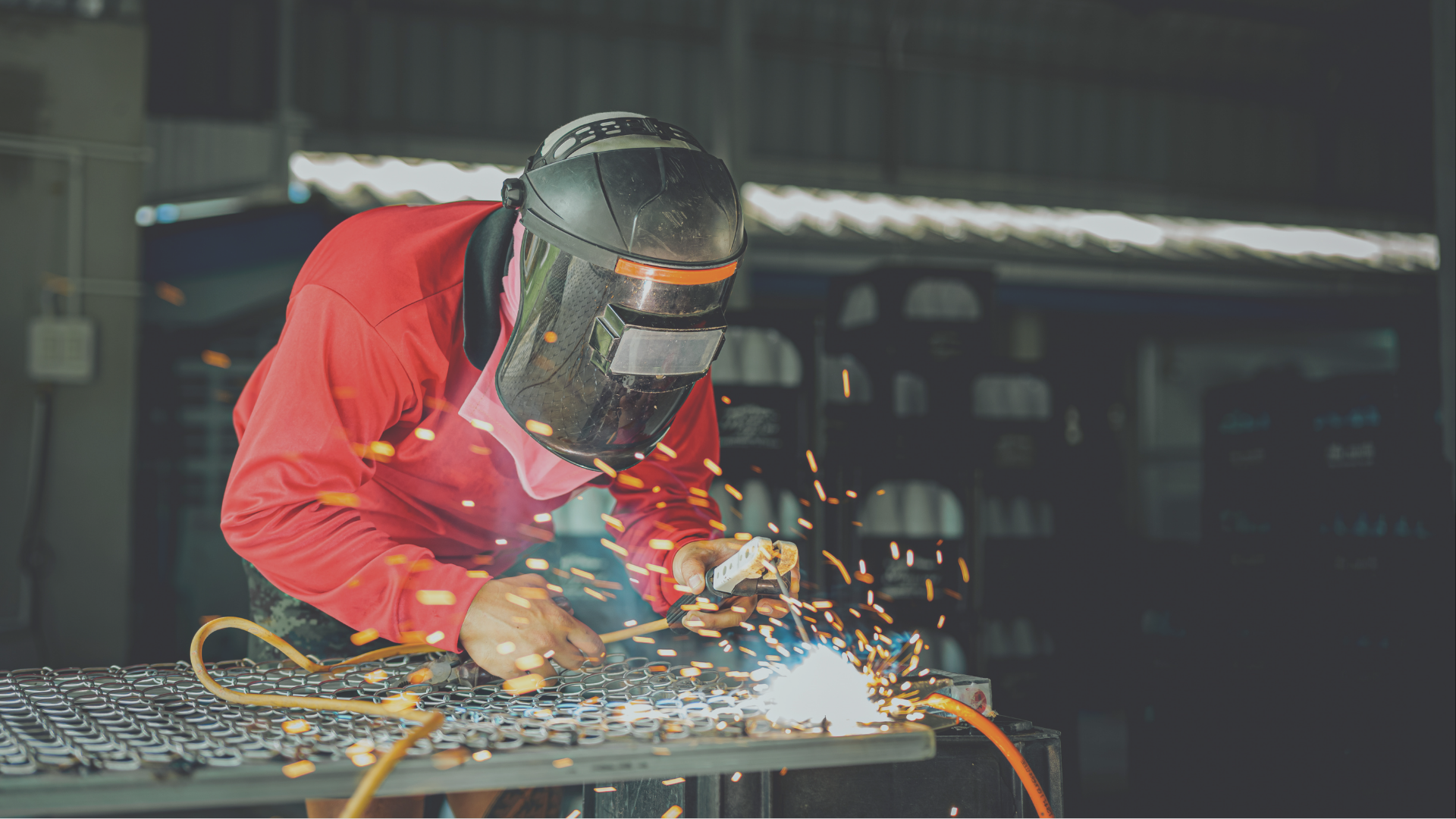 Travailleur avec un masque de sidérurgie assemblant une pièce d'aluminium